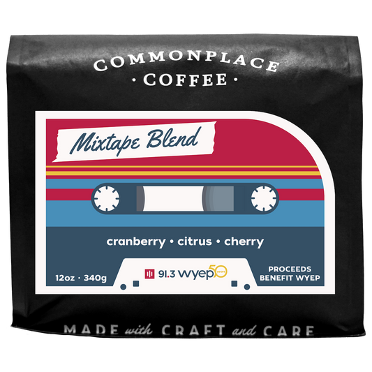 A black bag of 12oz Mixtape Blend from Commonplace Coffee. The label is red, yellow, and blue, and looks like a retro cassette tape.